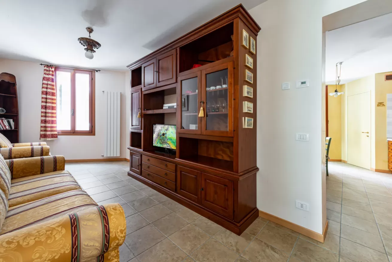 Una sala de estar con un gran mueble de madera para entretenimiento y asientos estampados.