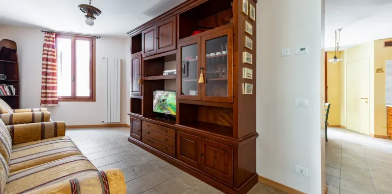 Una sala de estar con un televisor en un mueble grande de madera.