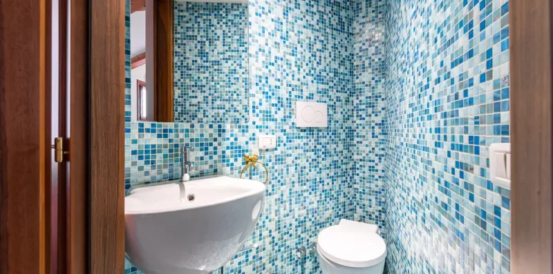 Un baño alicatado con lavabo e inodoro.