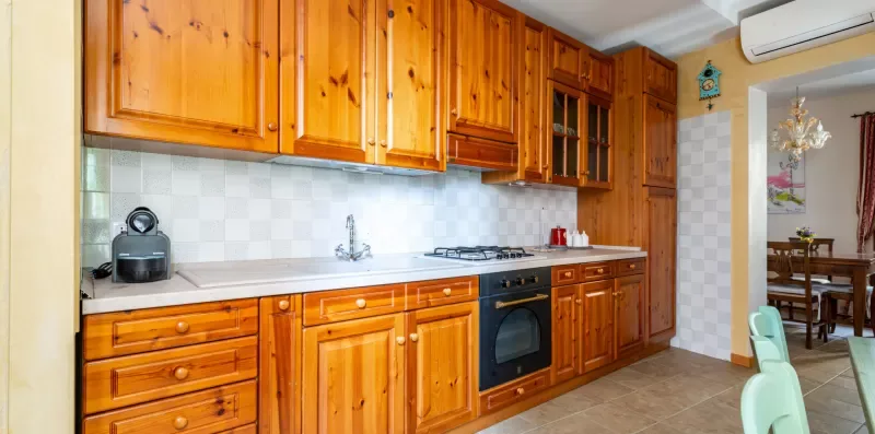 Una cocina con armarios de madera, una encimera y un horno integrado.
