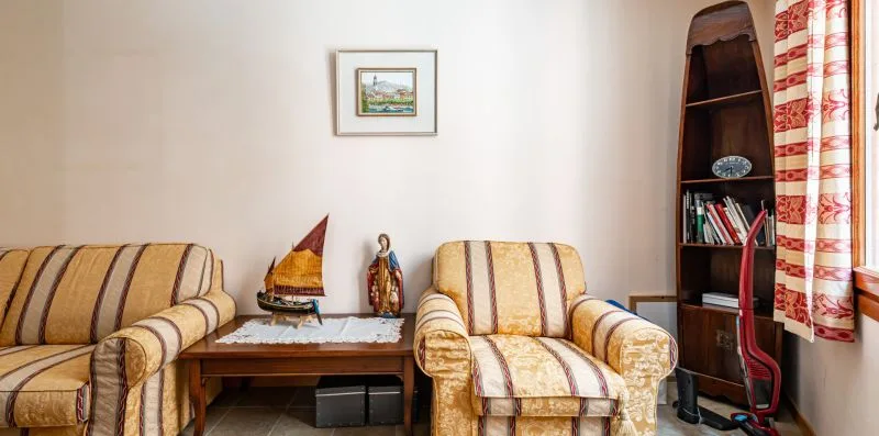 Una sala de estar con asientos tapizados y una mesa pequeña.