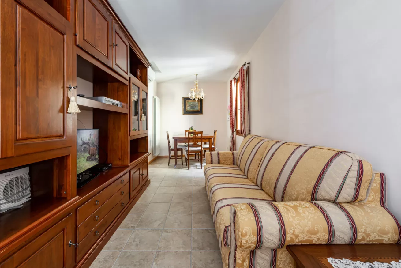 Una sala de estar con un sofá a rayas y un mueble de madera.