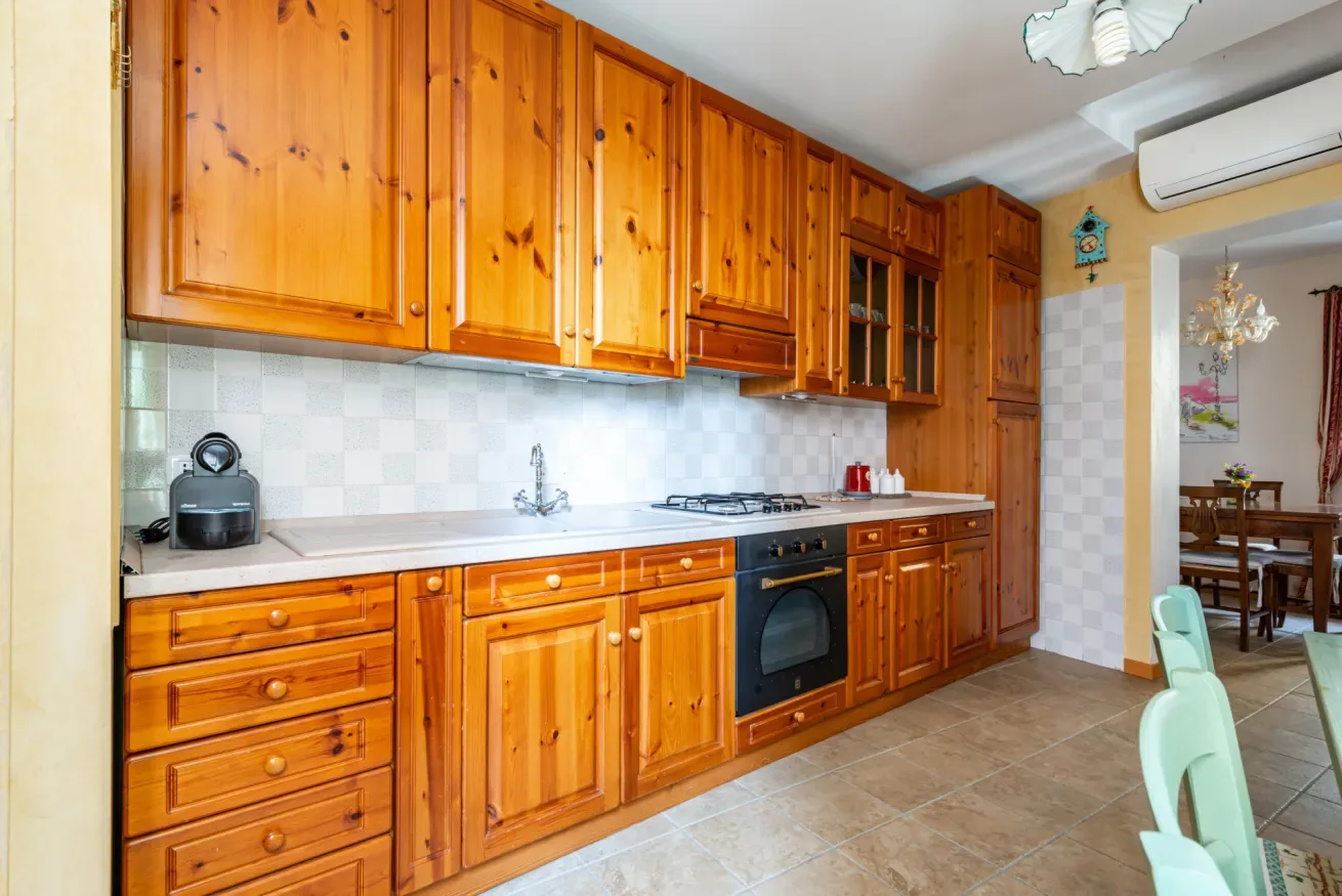 Una cocina con armarios de madera, una encimera y una placa de cocción.