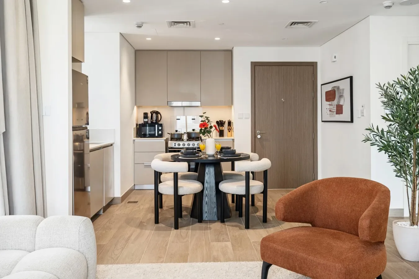 Una luminosa cocina abierta al comedor, con una mesa y asientos alrededor.