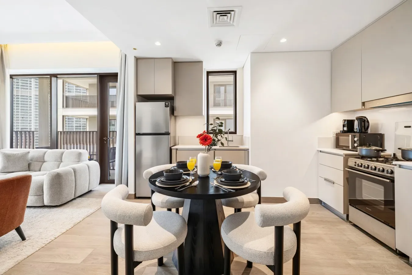 Espacio abierto de sala, comedor y cocina con una mesa redonda.