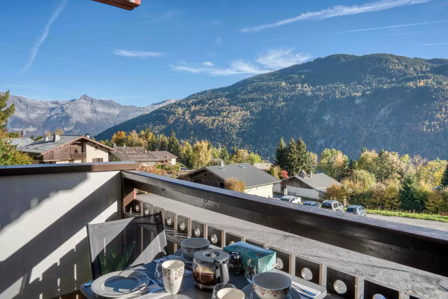 A mountain-view balcony with outdoor seating and a clear blue sky.