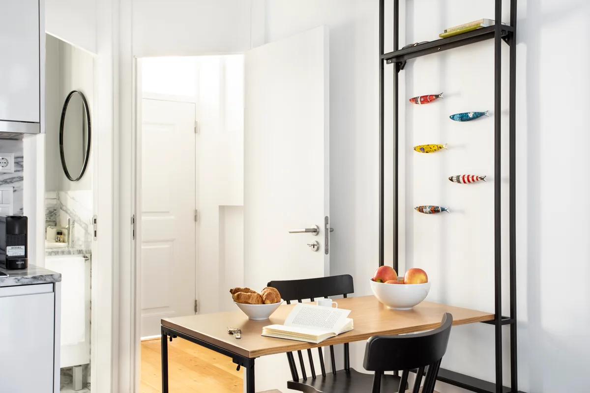 Comedor con una mesa con fruta y pan junto a una puerta abierta.