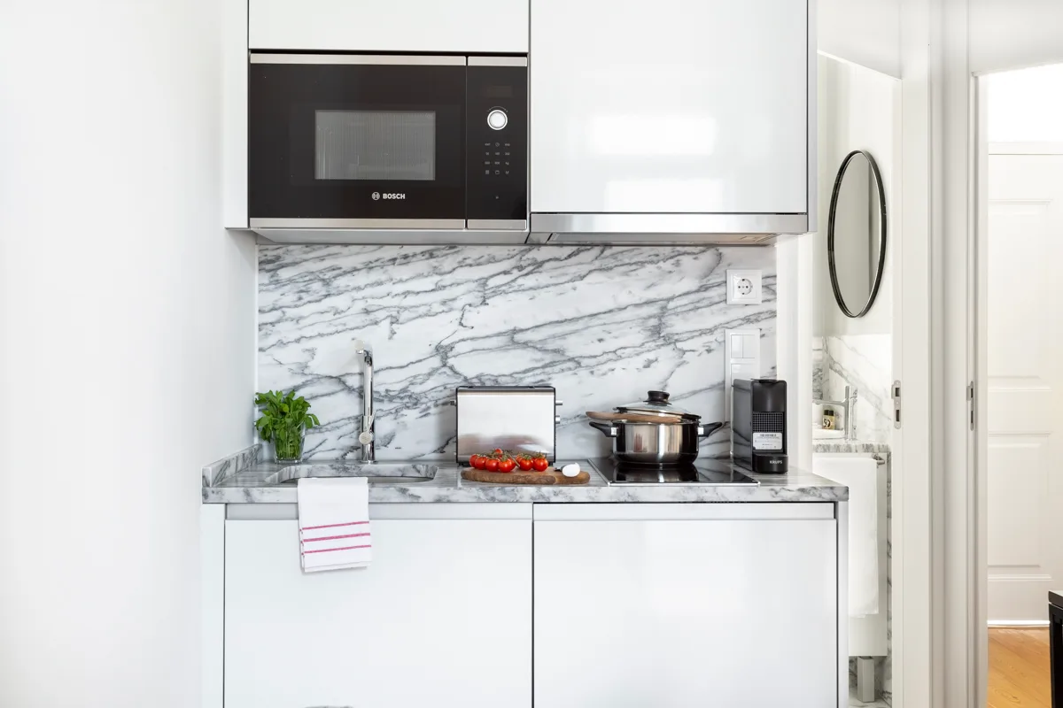 Una cocina compacta con encimera, fregadero y microondas integrado.