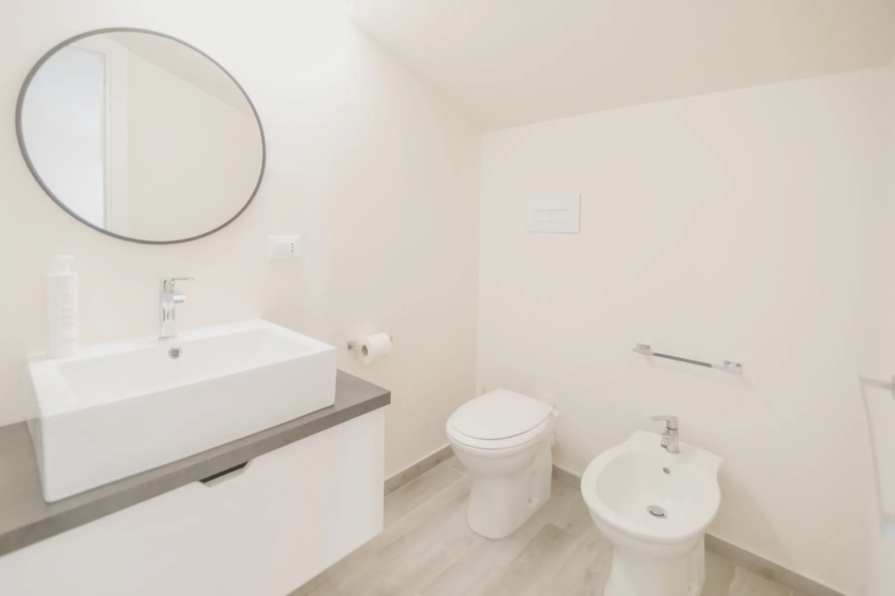 Un baño luminoso con lavabo, inodoro y bidé.