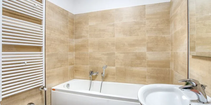 A tiled bathroom with a bathtub, shower, and sink.