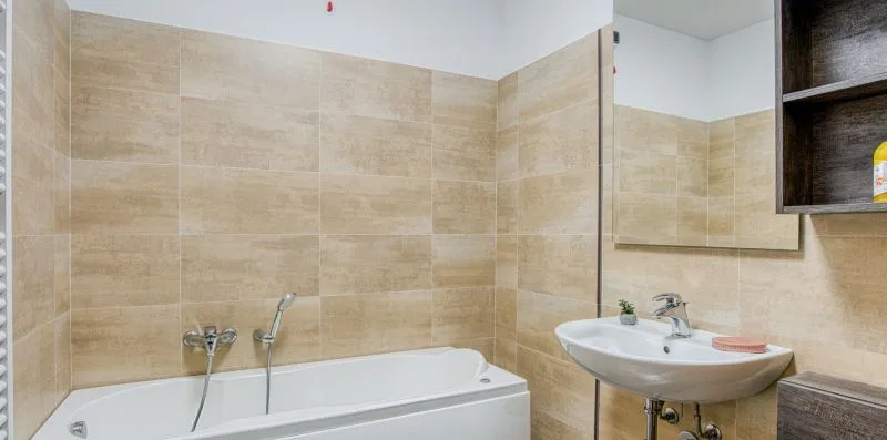A tiled bathroom with a bathtub and a sink.