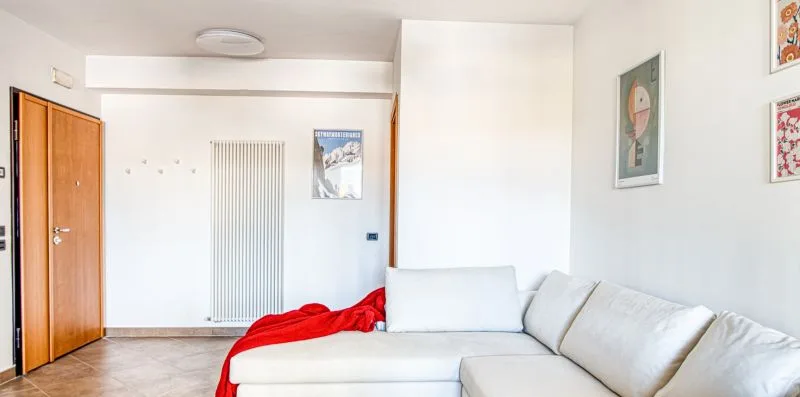 A bright living room with a white sectional sofa and wall art.
