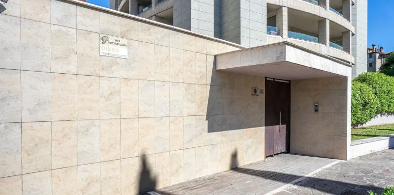 A building entrance with a dark door set into a pale stone facade.