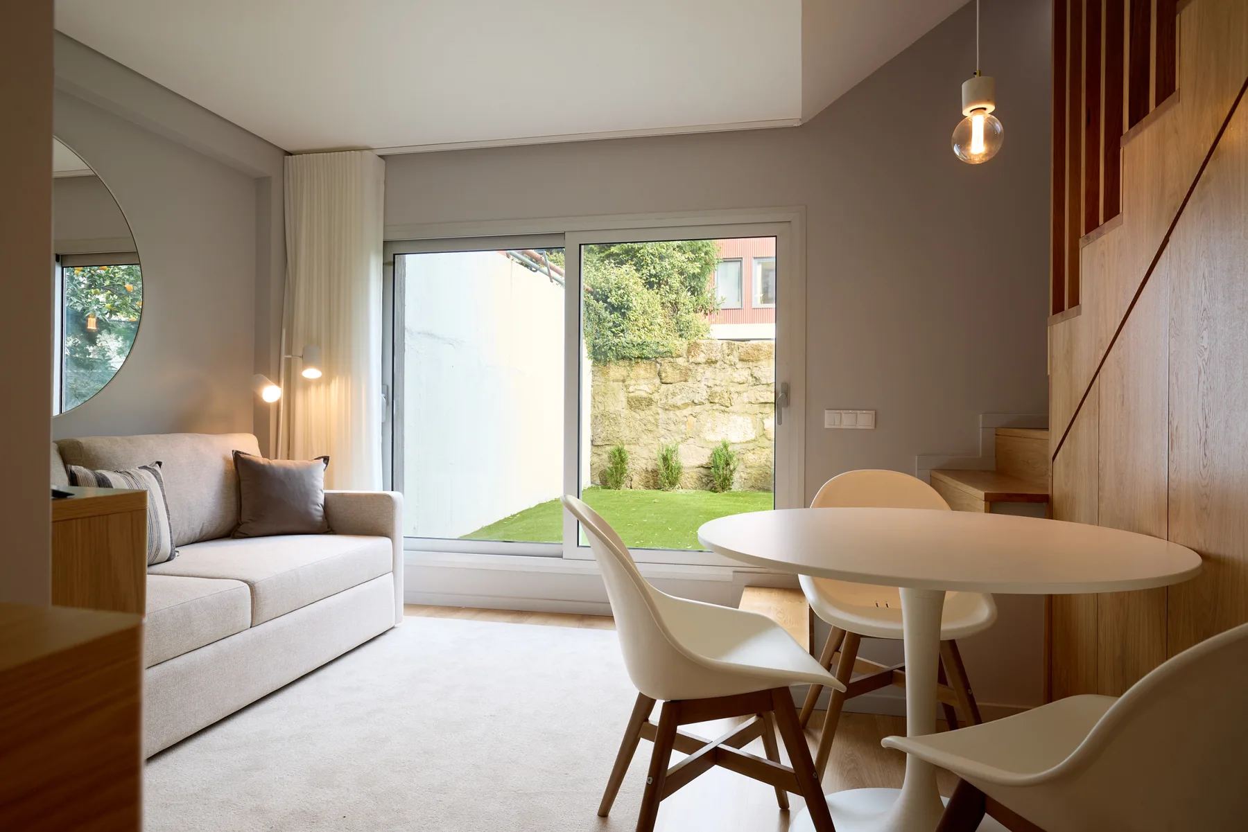A bright living and dining area with seating beside large glass doors.