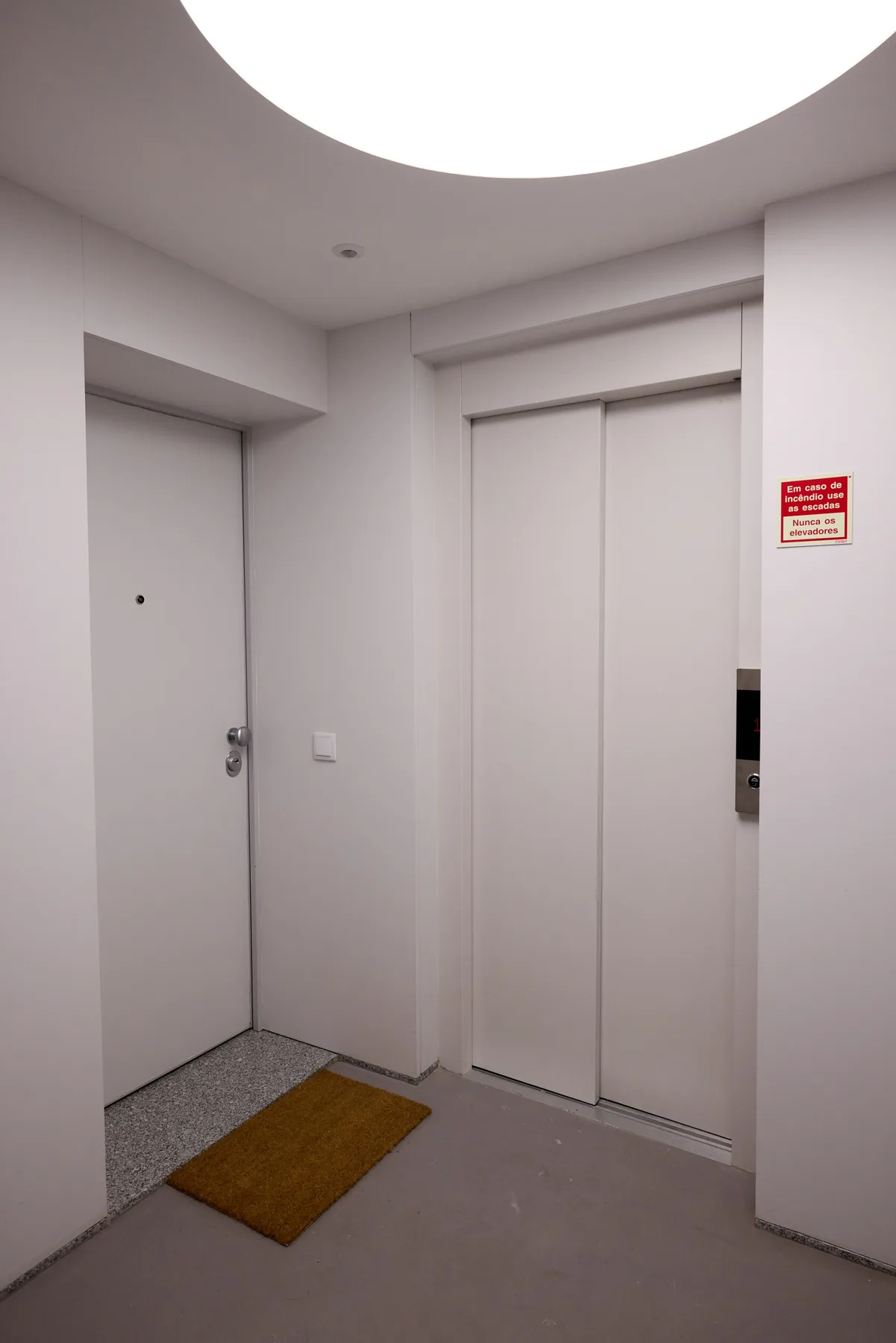 Una entrada interior con una puerta cerrada y puertas de ascensor.
