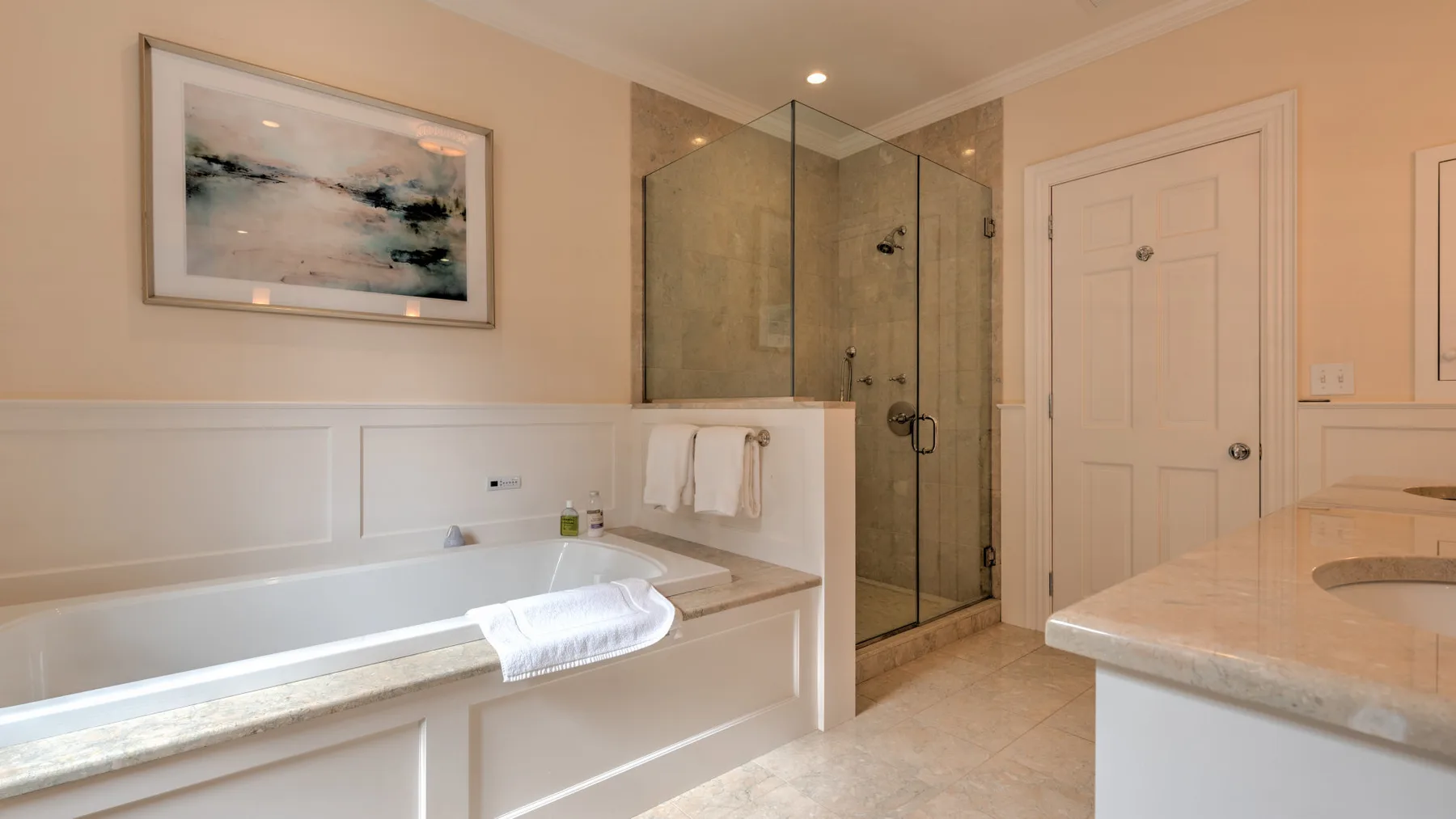 Un baño con bañera, ducha de vidrio y lavabo.