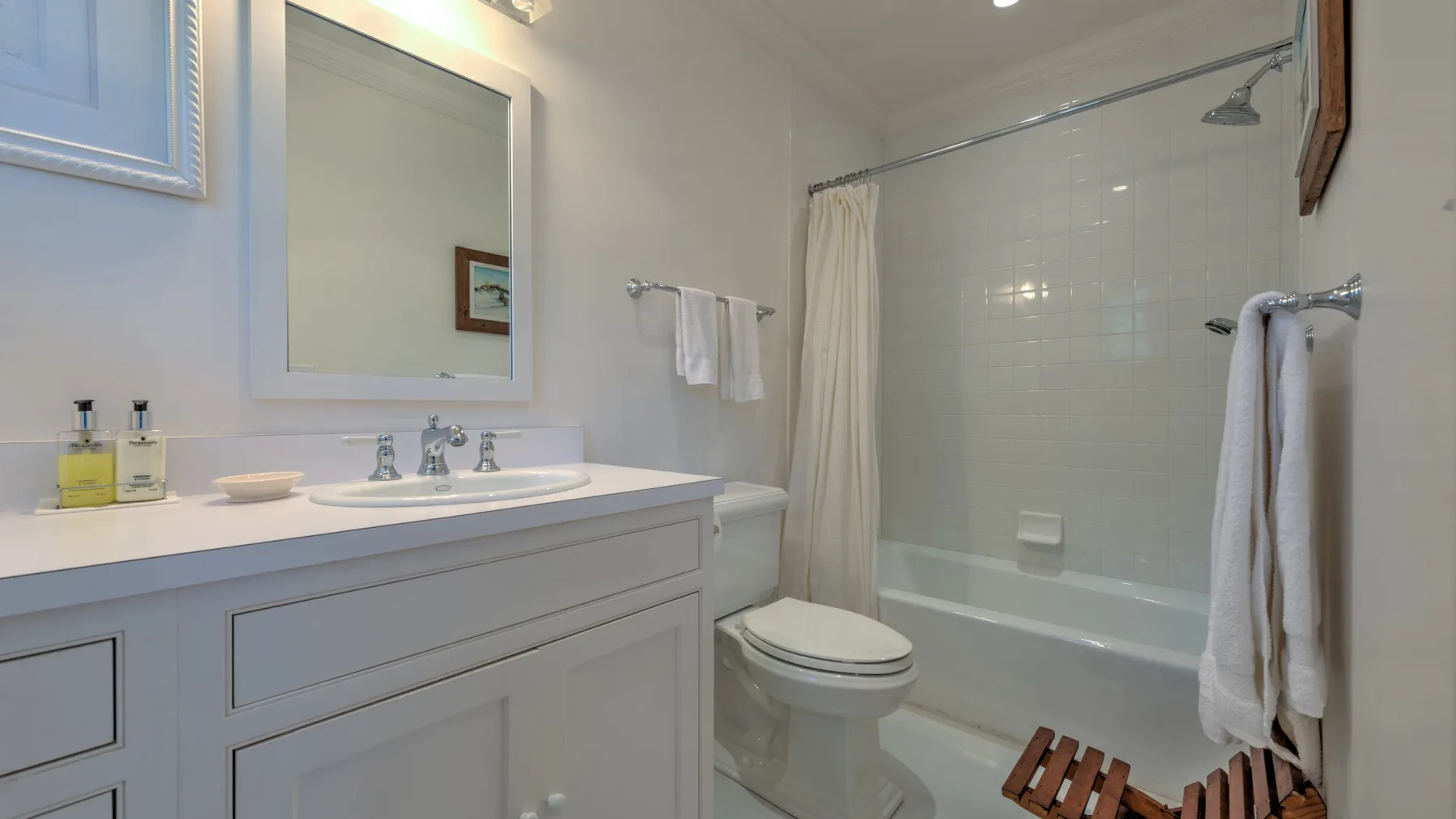 Un baño con lavabo, inodoro y bañera detrás de una cortina de ducha.