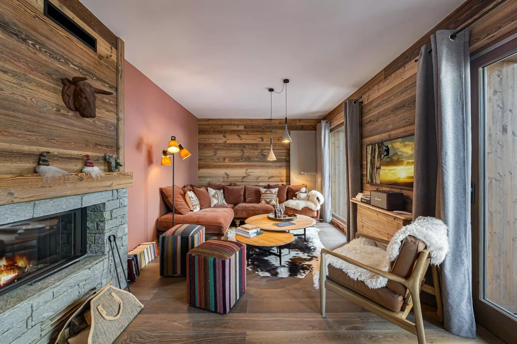 Una sala de estar con asientos alrededor de una mesa baja junto a una chimenea de piedra.