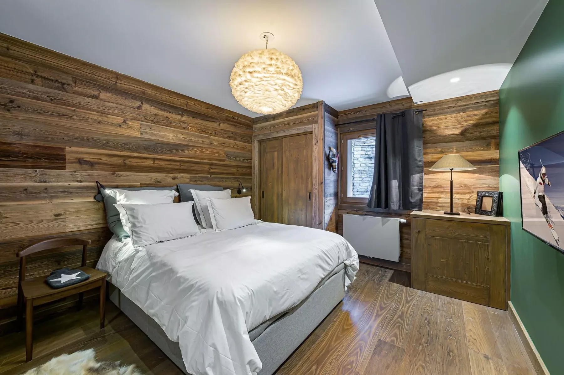 Un dormitorio con una cama bien tendida y paredes de madera.