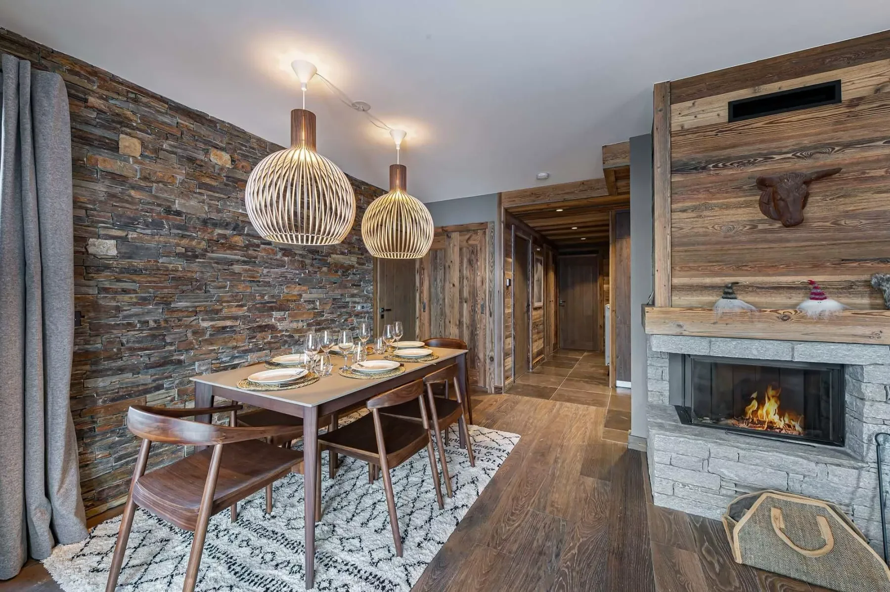 Un comedor con una mesa de madera junto a una chimenea de piedra.