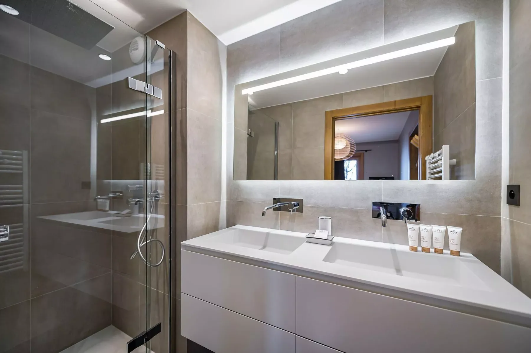 Un baño moderno con un lavabo amplio y una ducha de cristal.
