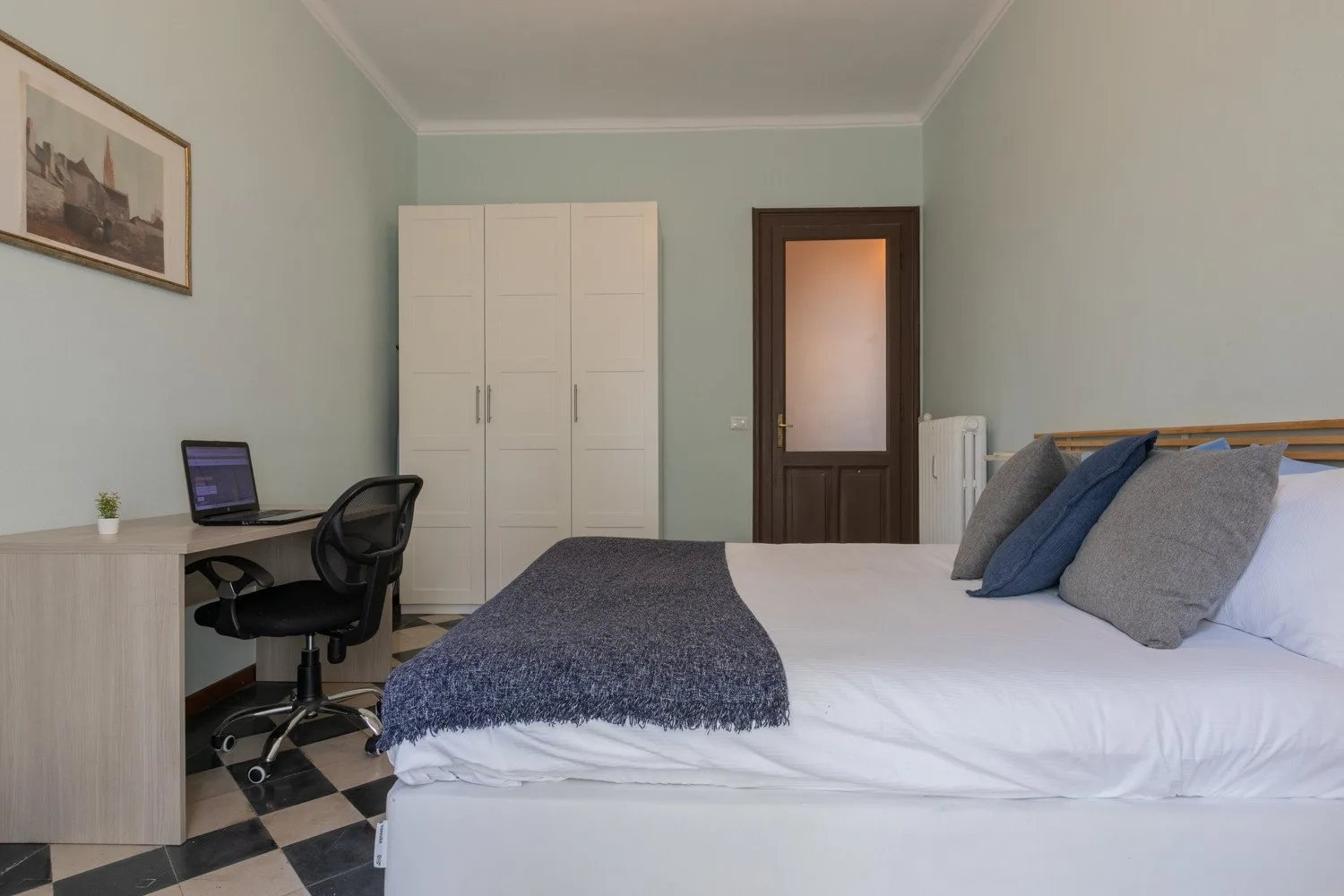 Un dormitorio con una cama, un escritorio y un armario.