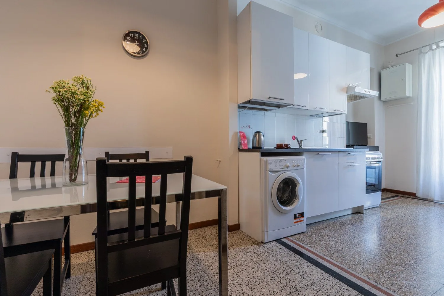 Comedor con mesa y sillas junto a una cocina compacta.