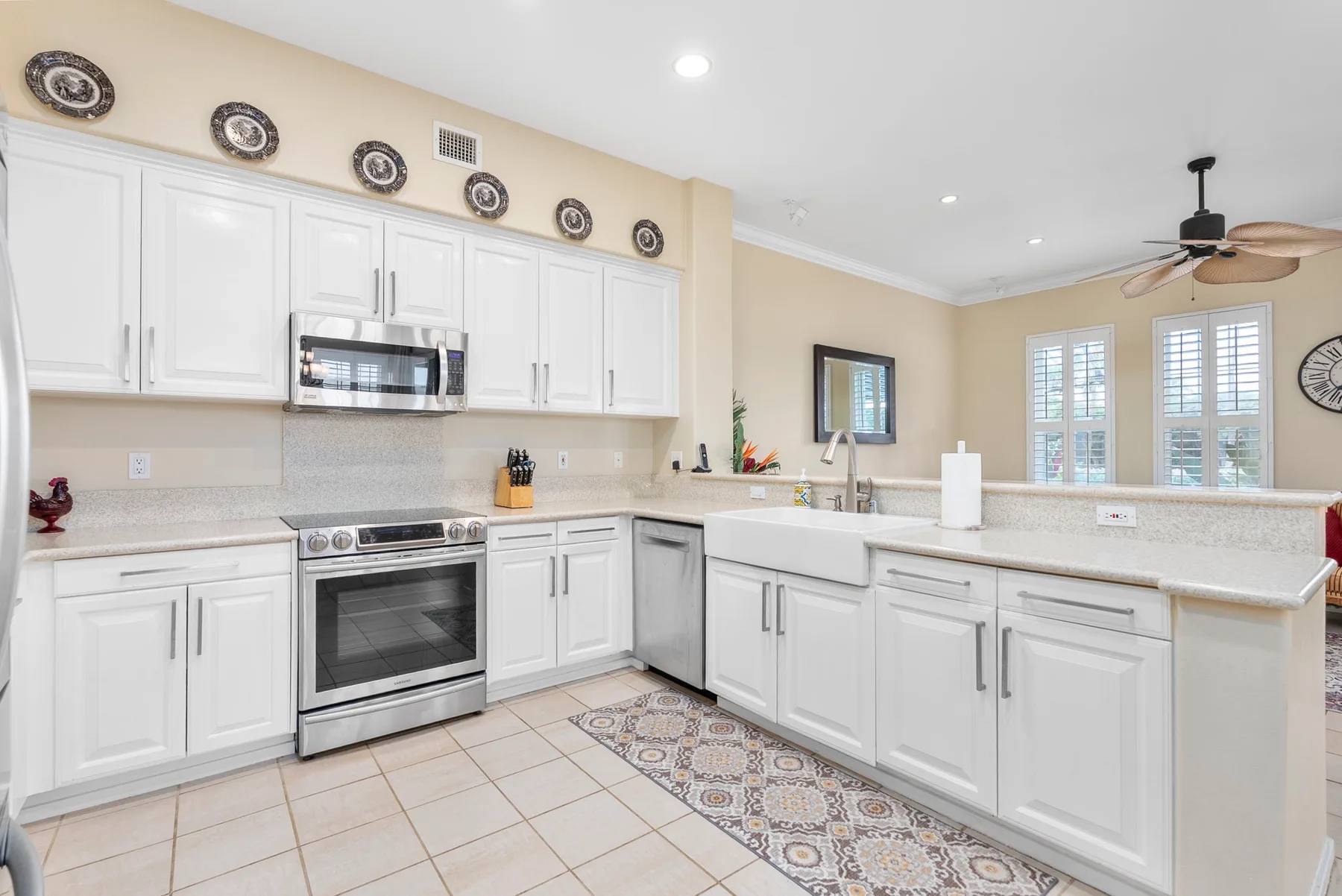 A bright kitchen with white cabinetry, stainless steel appliances, and a central island.