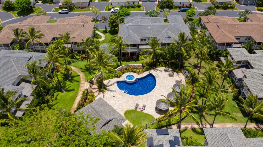 Aerial view of a landscaped residential complex with a central swimming pool.