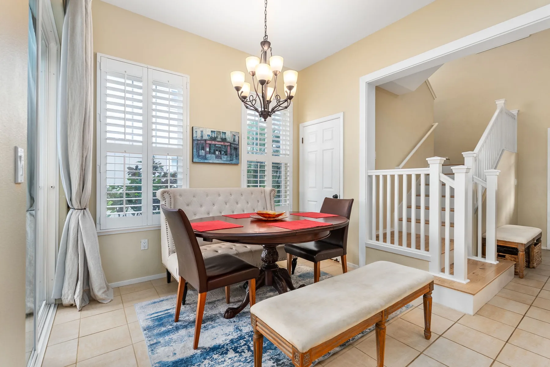 A dining area with a table and chairs beside a staircase.