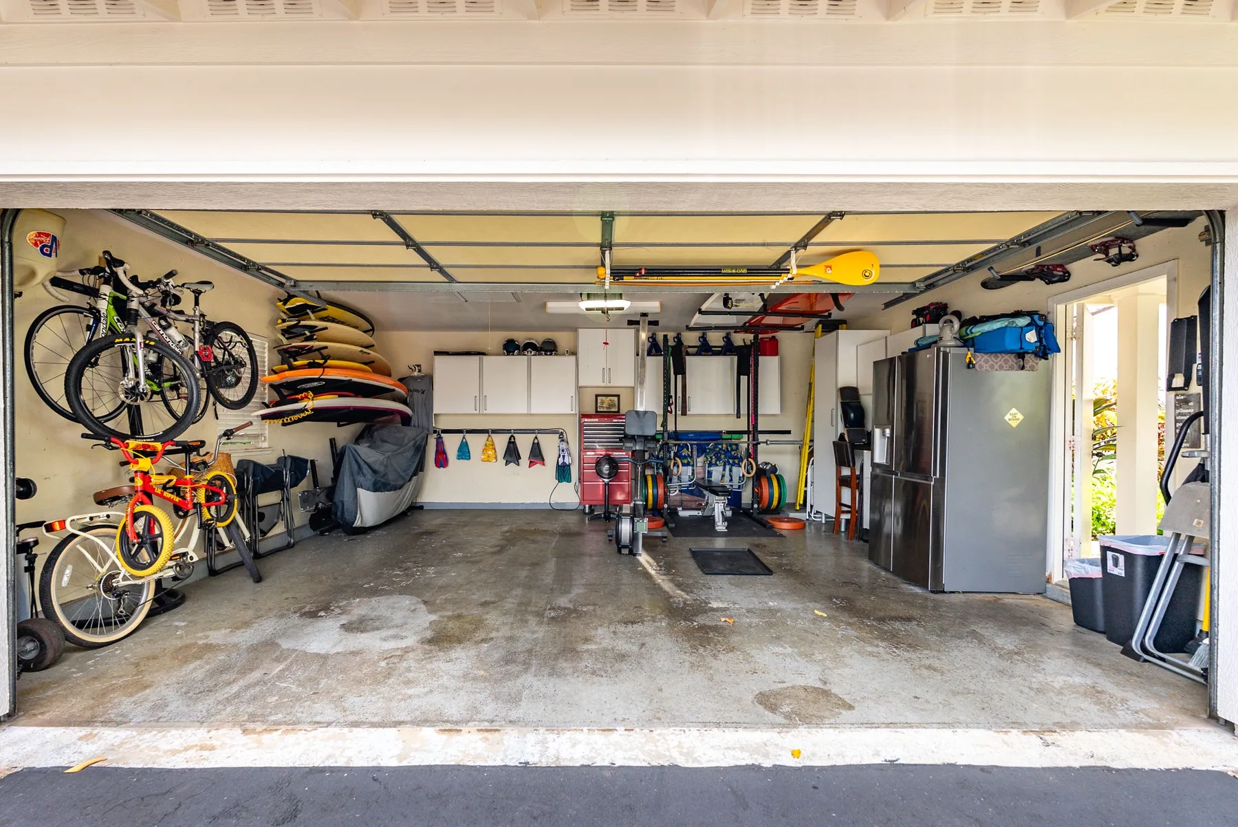 A garage filled with bicycles, sports equipment, and storage cabinets.