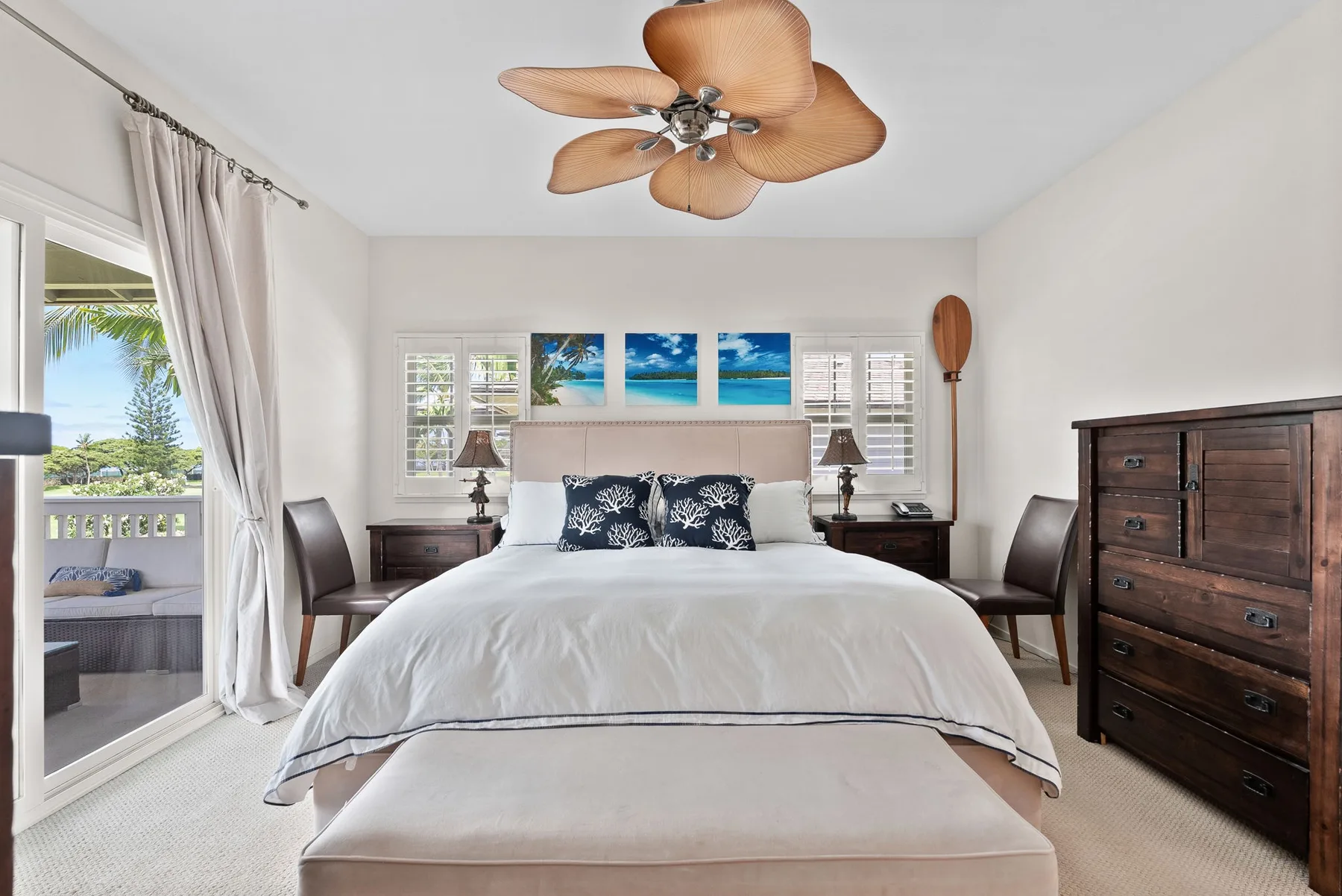 A bright bedroom with a large bed and glass doors opening onto a balcony.