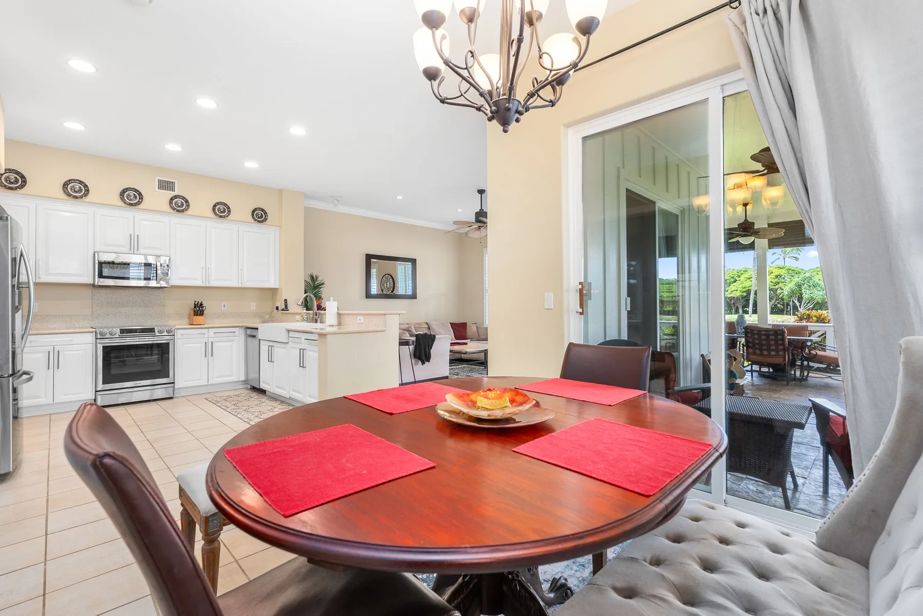 A dining area with a wooden table beside a bright kitchen and sliding glass doors.