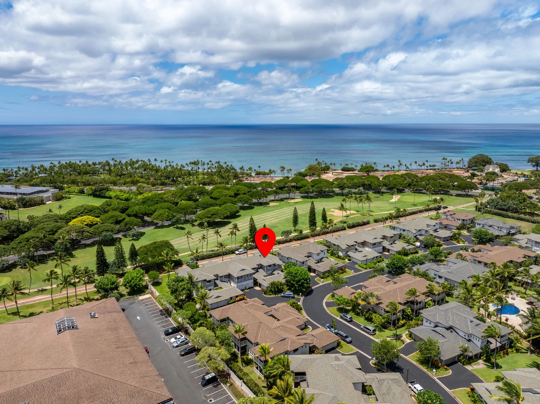 Aerial view of a coastal neighborhood with the ocean visible beyond.