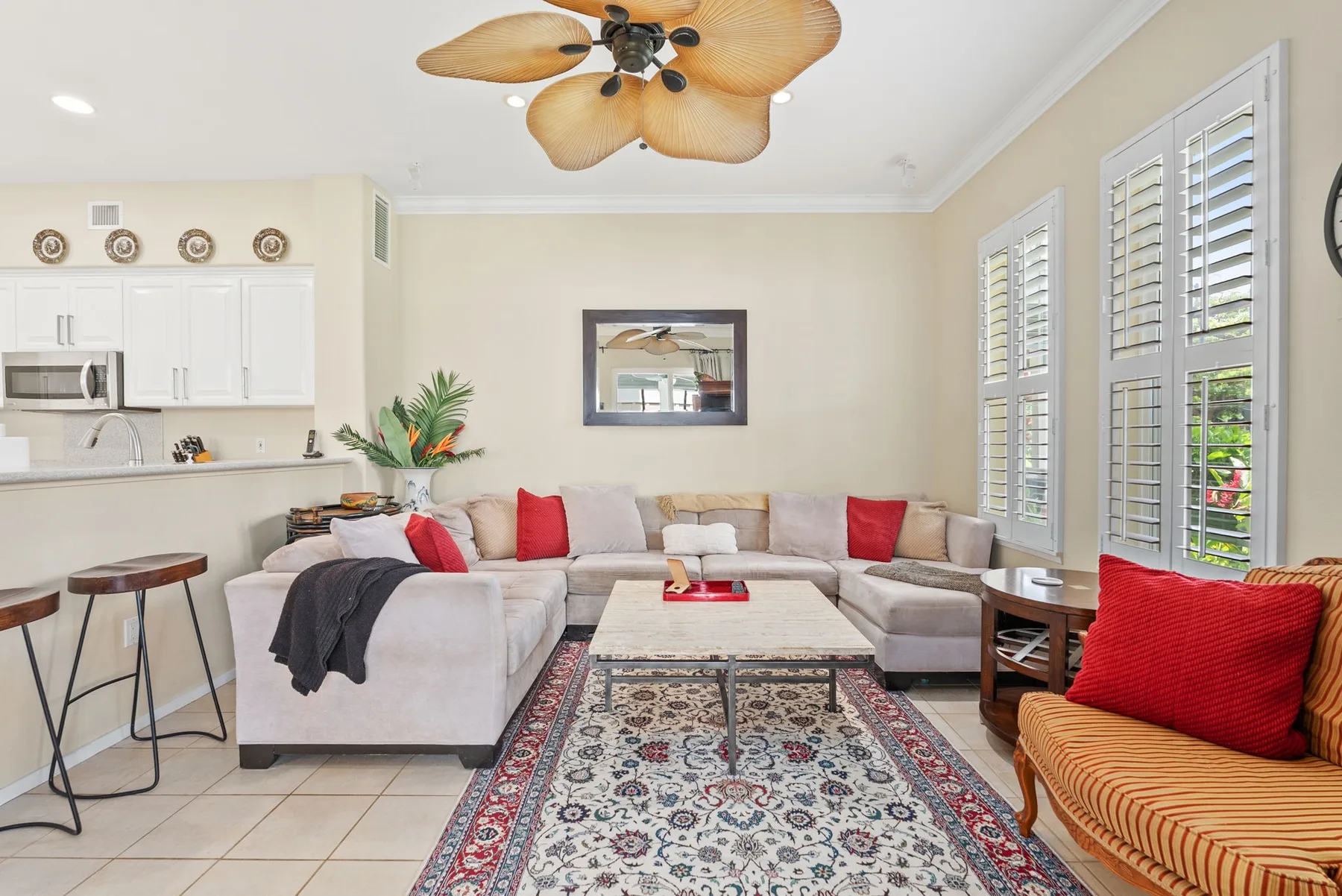 A bright living room with a sectional seating area and a patterned rug.