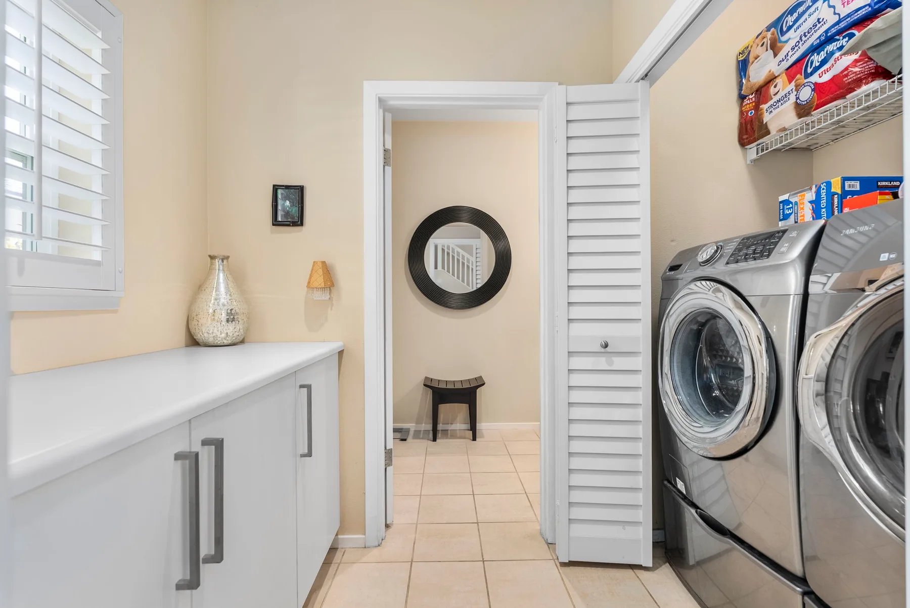 A laundry room with front-loading machines and a long counter.