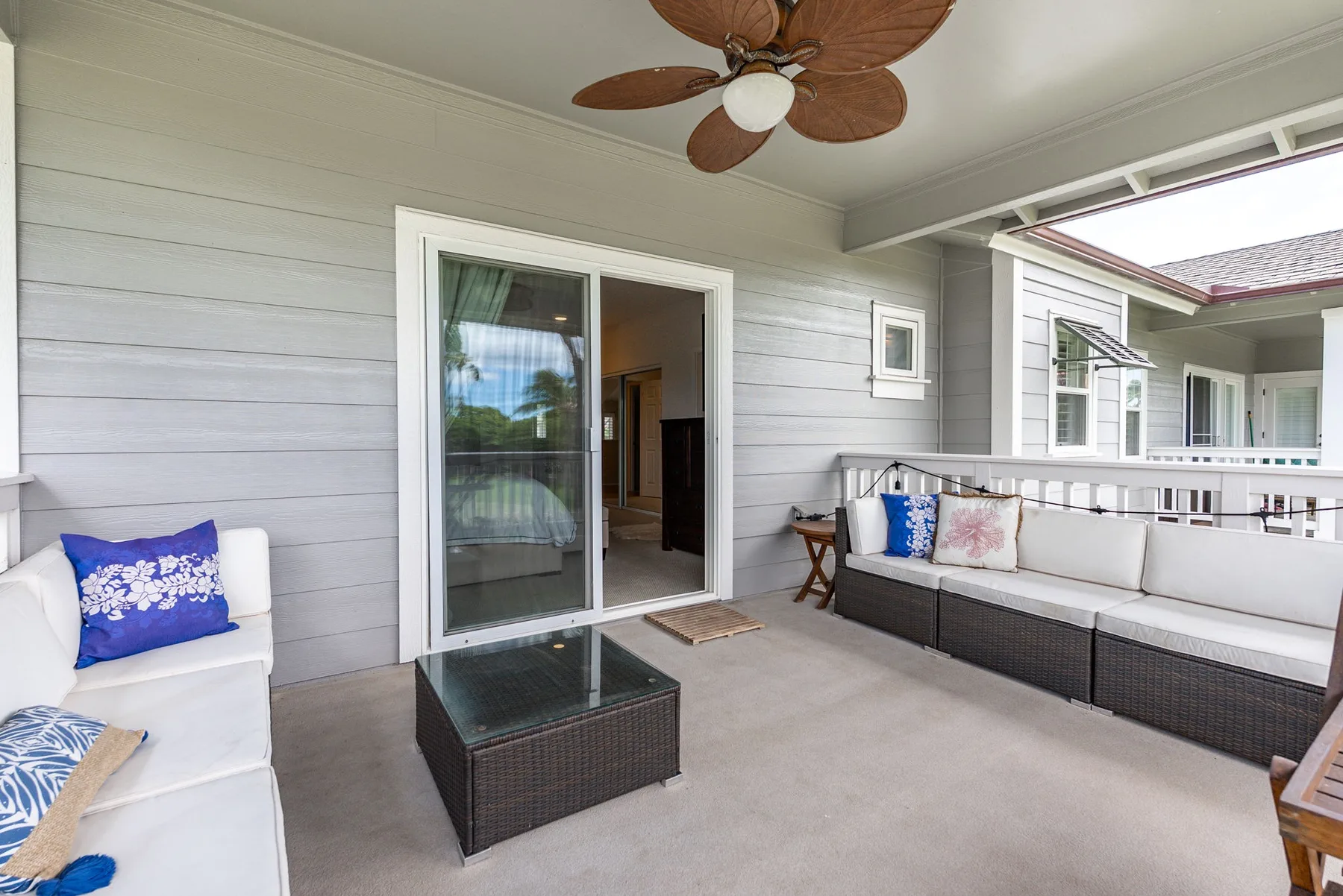 A covered patio with outdoor seating and a sliding glass door.