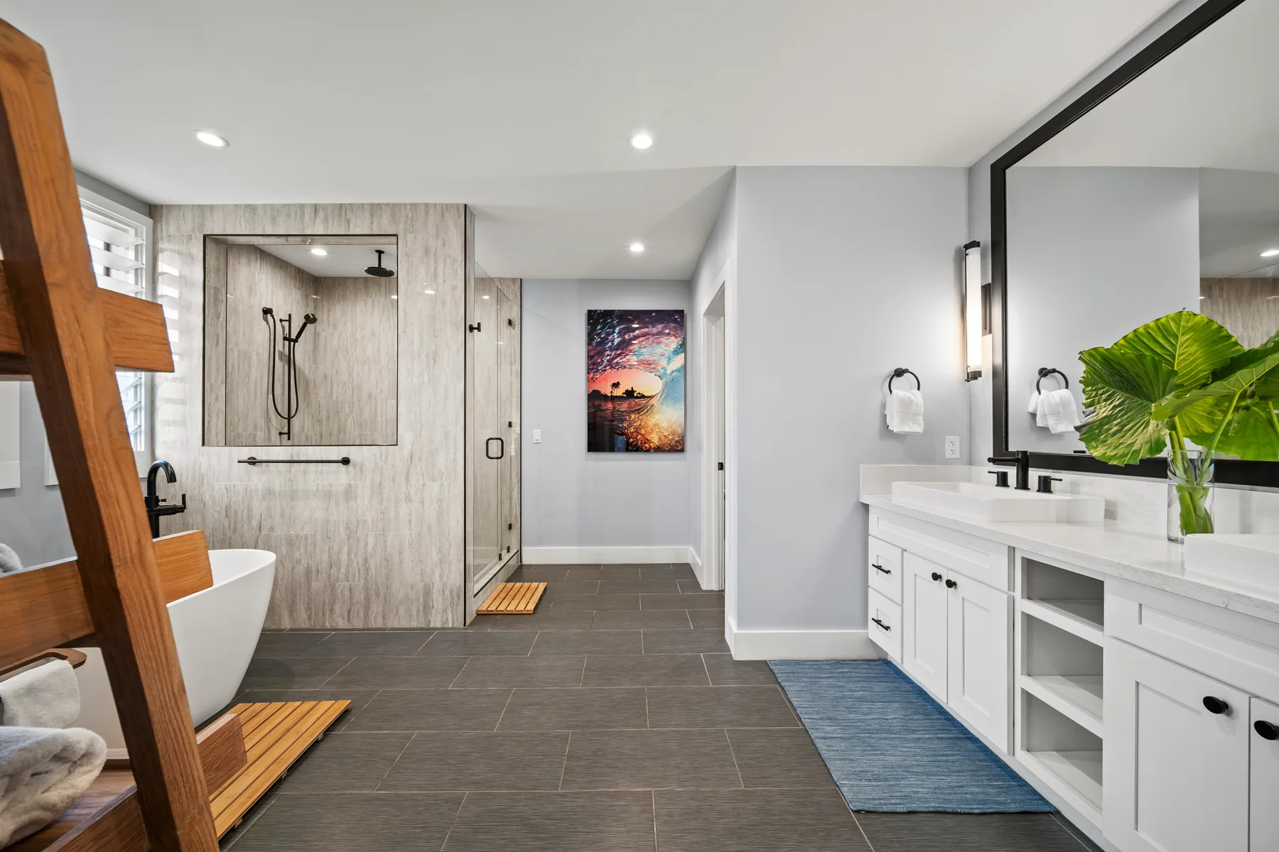 Un baño moderno con ducha, bañera exenta y lavabo doble.