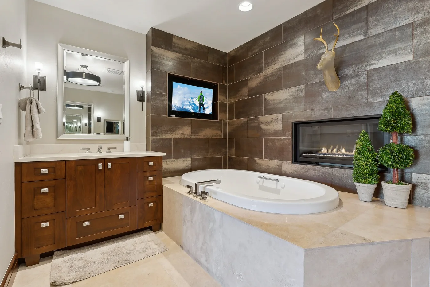 Un baño amplio con una bañera grande, un tocador de madera y paredes revestidas de azulejos.