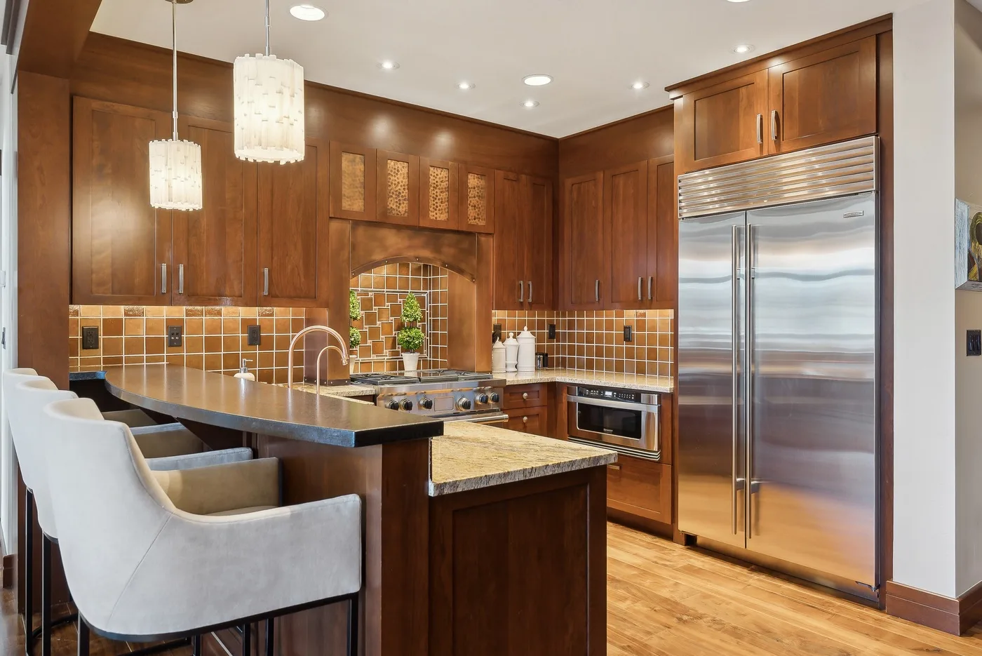 Una cocina amplia con gabinetes de madera oscura, una isla central y electrodomésticos de acero inoxidable.