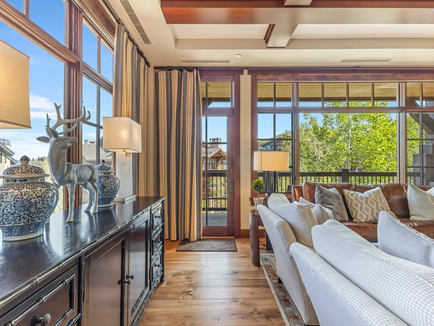 Una sala luminosa con asientos junto a grandes ventanas y puertas de vidrio.