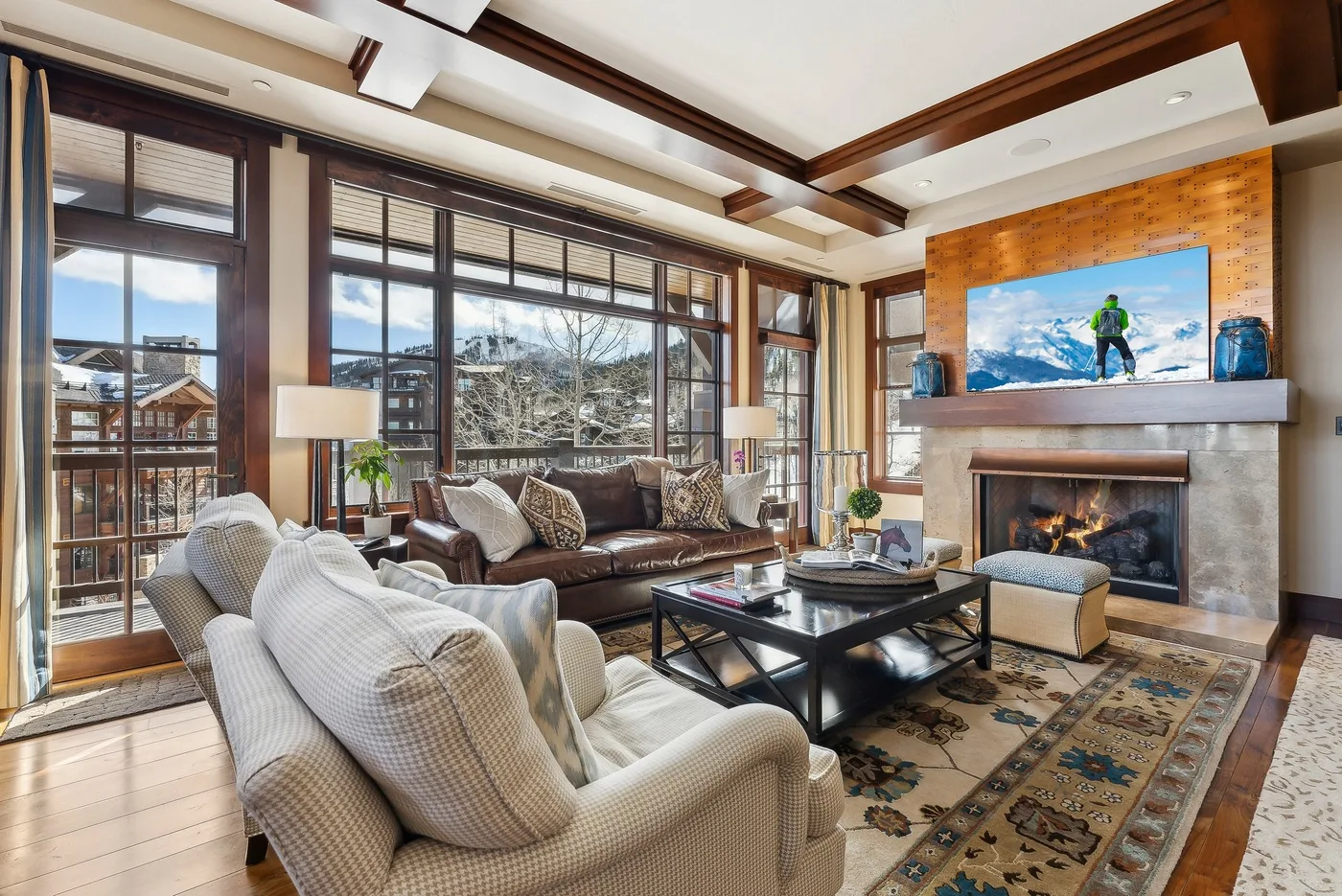 Una sala de estar amplia con grandes ventanas, asientos y una chimenea.