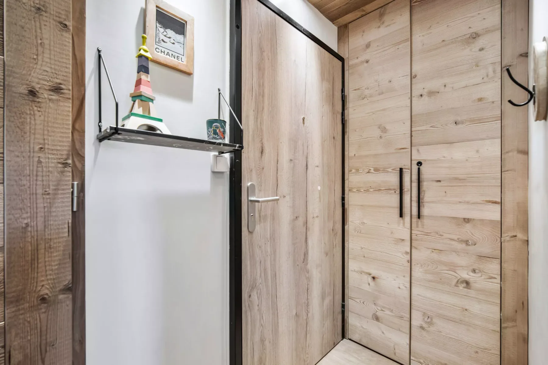 A wood-paneled entryway with a door and built-in storage.