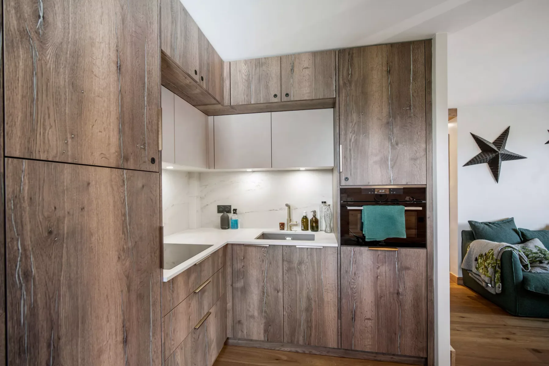 A compact kitchen with wood-toned cabinets and a built-in oven.