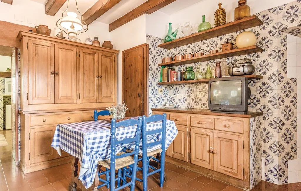 Una cocina y comedor rústicos con muebles de madera y un mantel a cuadros.