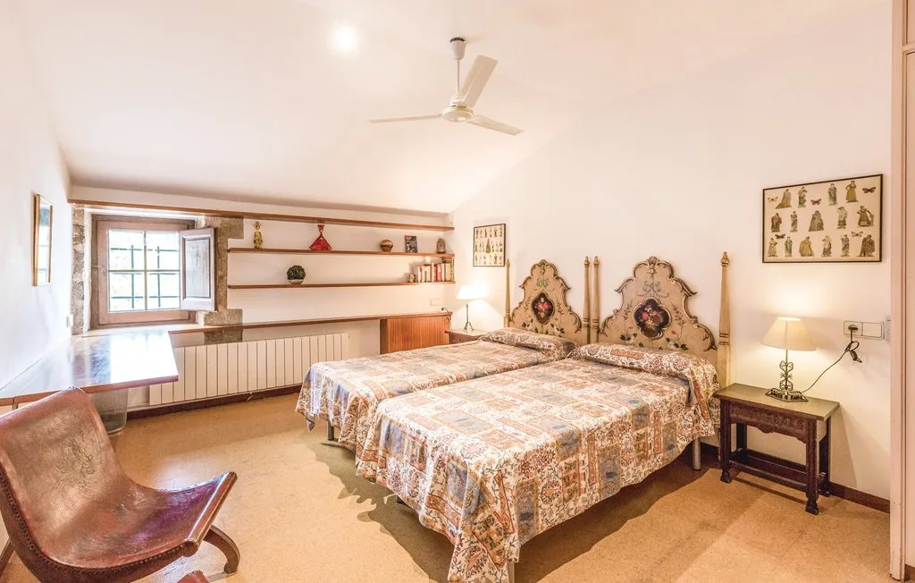 Un dormitorio con dos camas, un ventilador de techo y una ventana.