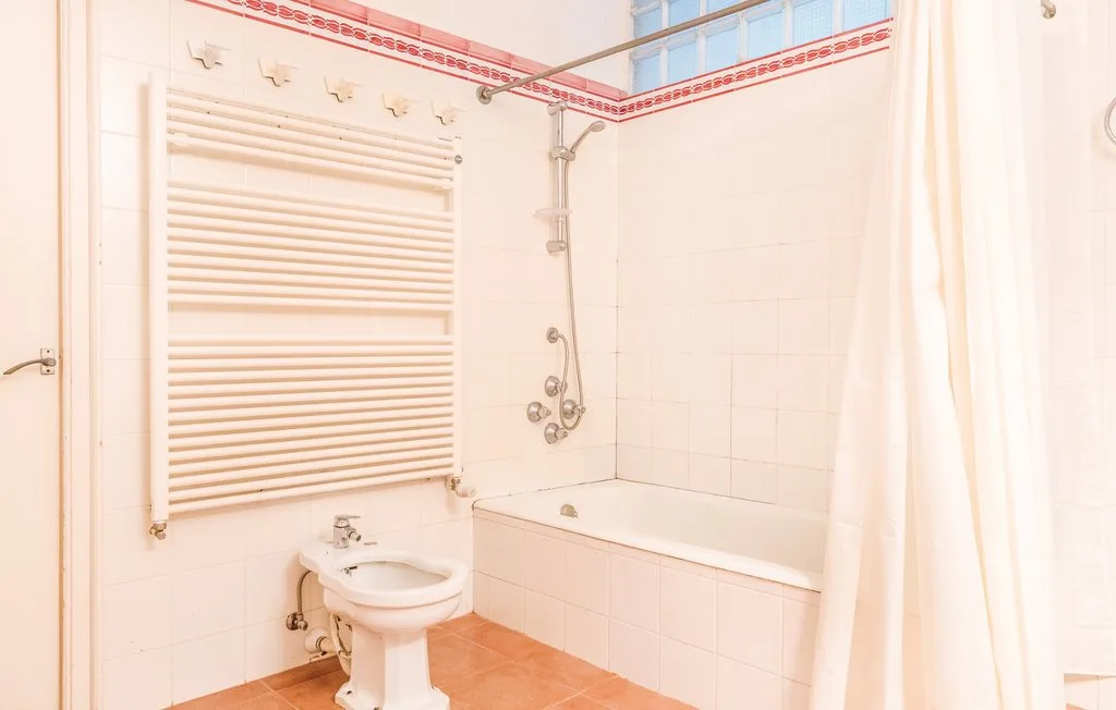 Un baño alicatado con bañera, ducha y bidé.
