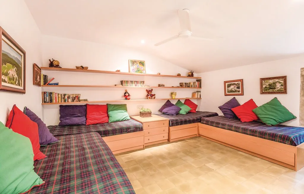Una habitación luminosa con bancos integrados, cojines de colores y estantes en la pared.