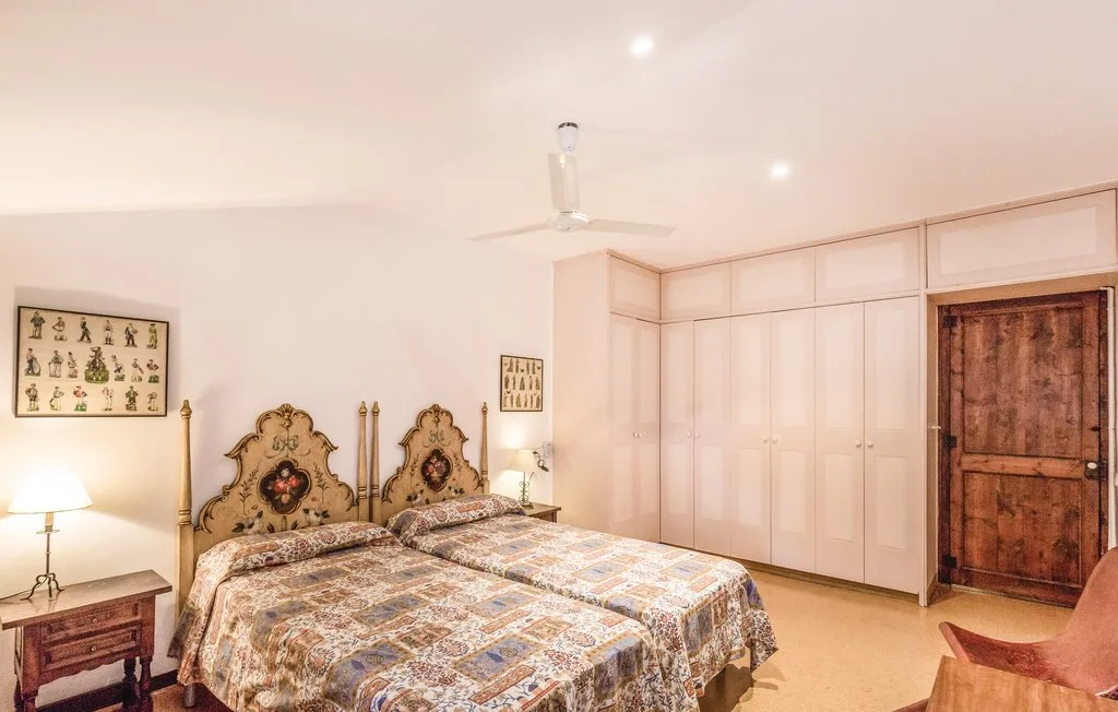 Un dormitorio con dos camas, armarios empotrados y una puerta de madera.