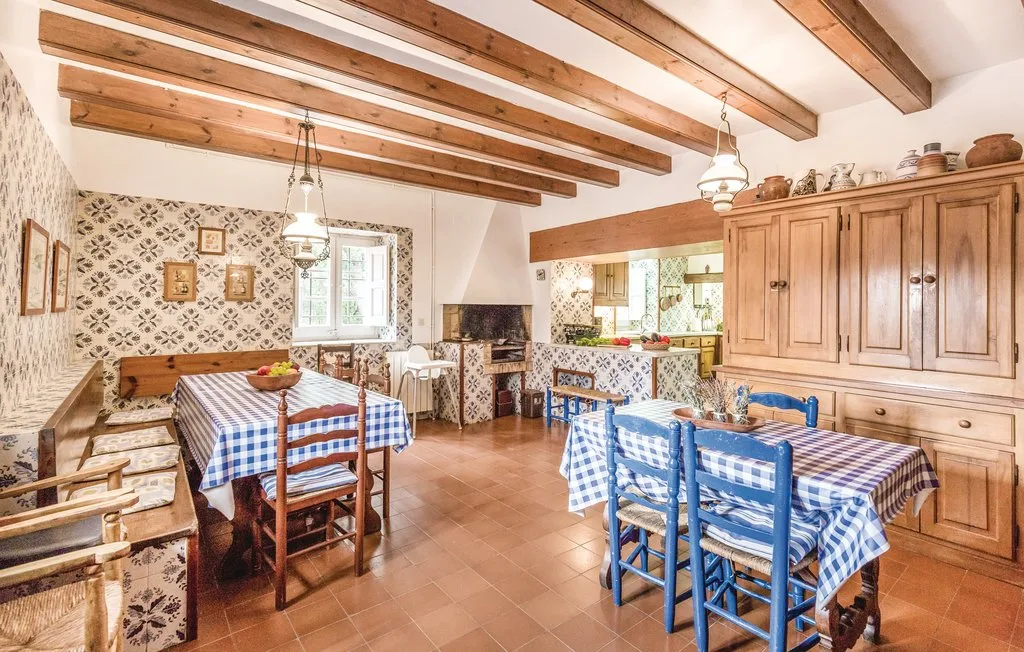 Un comedor rústico con manteles a cuadros y vigas de madera vistas en el techo.